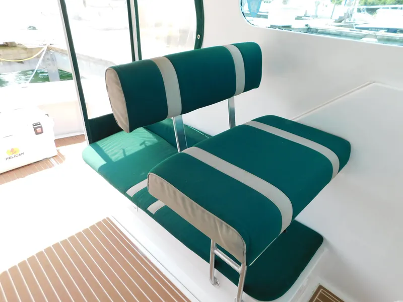 Slide: The Image of 1999 Mainship Pilot 30 interior with green and gray cushioned seating. - 31