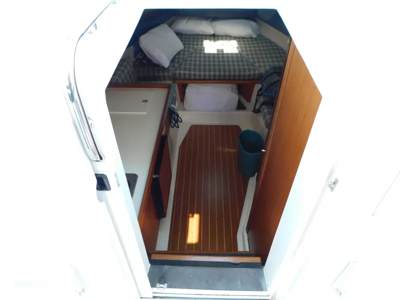 Slide: The Image of 1999 Mainship Pilot 30 cabin interior with bed, wooden floor, and compact layout. - 34