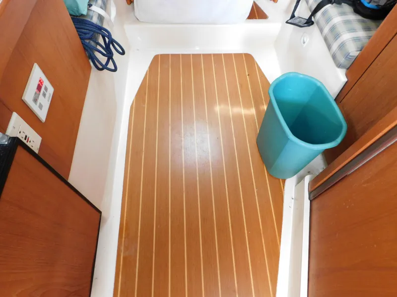 Slide: The Image of 1999 Mainship Pilot 30 interior with wood flooring and blue trash bin. - 38