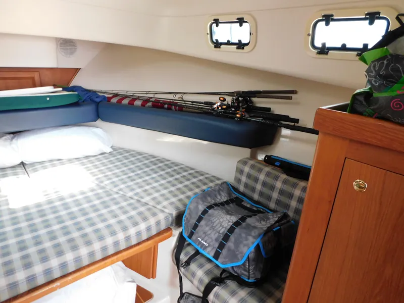 Slide: The Image of 1999 Mainship Pilot 30 cabin interior with fishing rods and gear bag. - 39