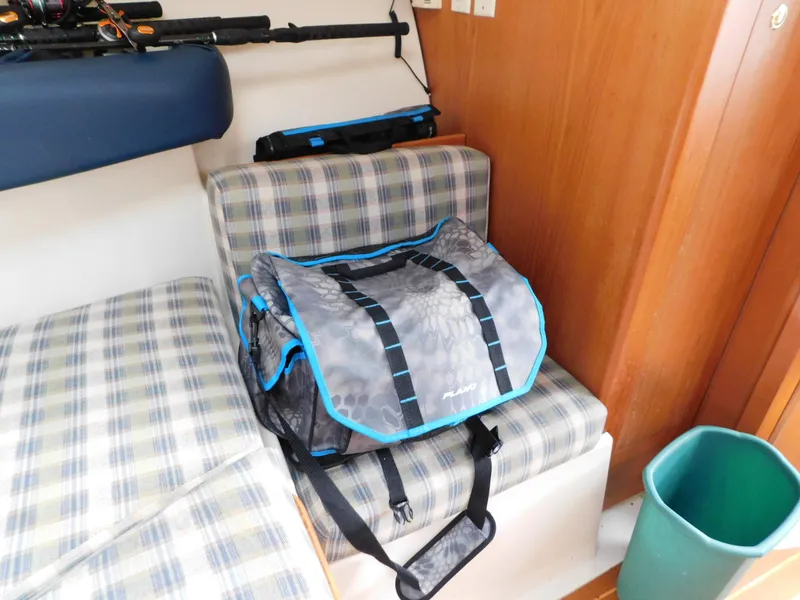 Slide: The Image of Interior of 1999 Mainship Pilot 30 with plaid seating and fishing gear. - 40