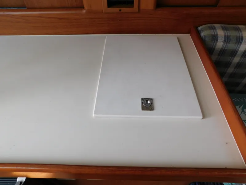 Slide: The Image of 1999 Mainship Pilot 30 interior table with wooden trim and plaid seating. - 47