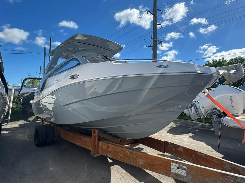 The Image of 2025 NX Boats NX280 XTREME on trailer under clear blue sky. - 1