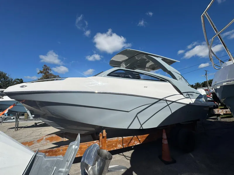 Slide: The Image of 2025 NX Boats NX280 XTREME on display under clear blue sky. - 2