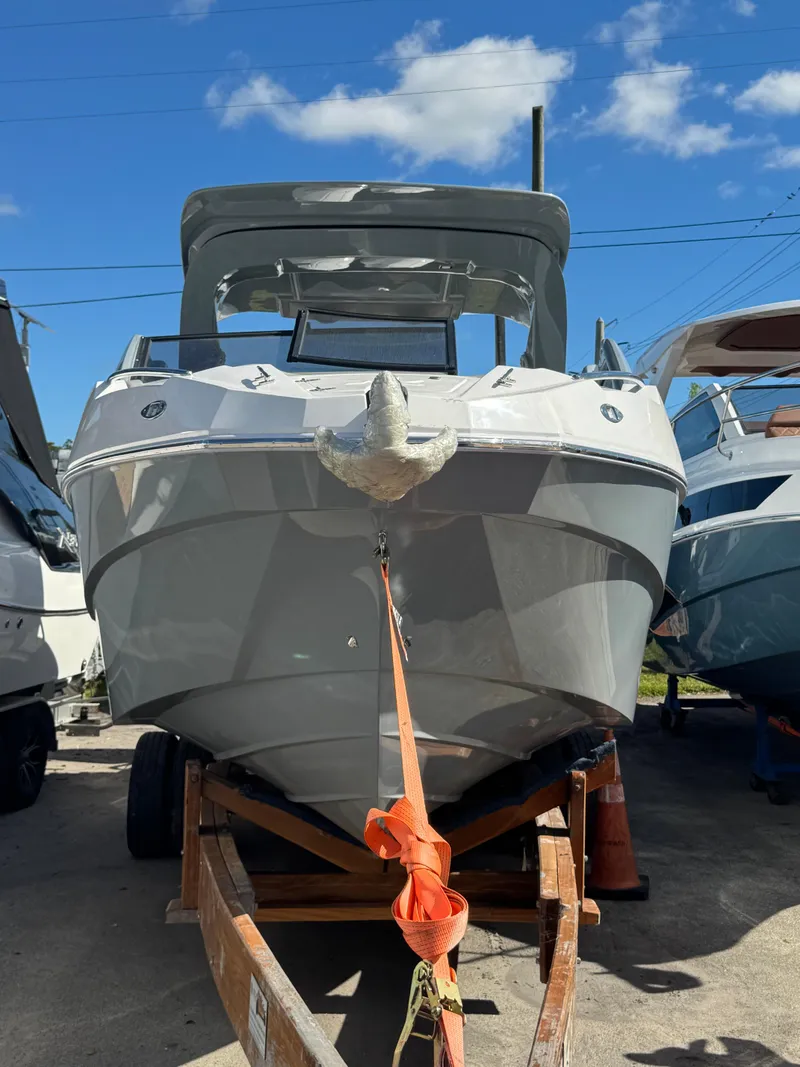 Slide: The Image of 2025 NX Boats NX280 XTREME on trailer under clear blue sky. - 8