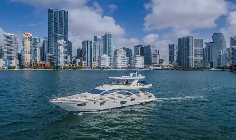 Slide: The Image of 2008 Azimut Flybridge yacht cruising near a city skyline under a blue sky. - 22