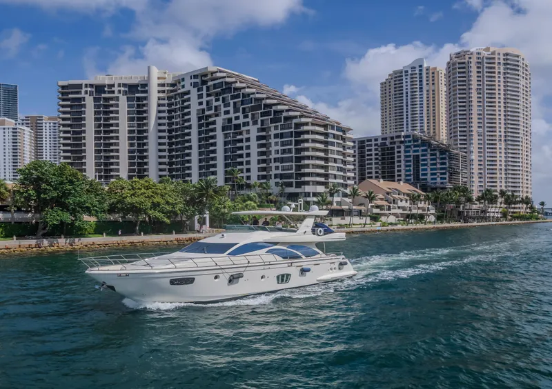 Slide: The Image of 2008 Azimut Flybridge yacht cruising near modern waterfront buildings. - 32