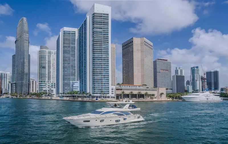 Slide: The Image of 2008 Azimut Flybridge yacht cruising near modern city skyline and waterfront buildings. - 43
