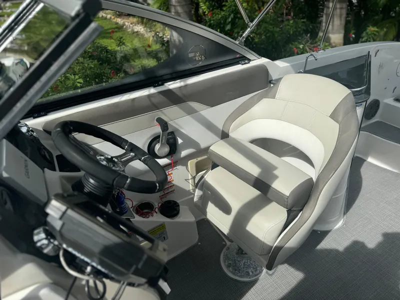 Slide: The Image of 2017 Starcraft 230 OB SCX EXT boat cockpit with steering wheel and captain's chair. - 17