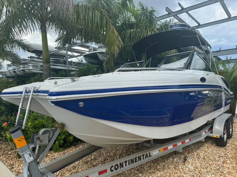 Slide: The Image of 2017 Starcraft 230 OB SCX EXT boat on trailer, surrounded by palm trees. - 3