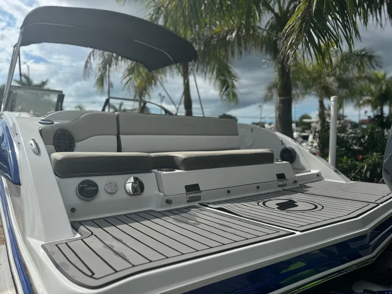 Slide: The Image of 2017 Starcraft 230 OB SCX EXT boat with seating, under a canopy, surrounded by palm trees. - 9