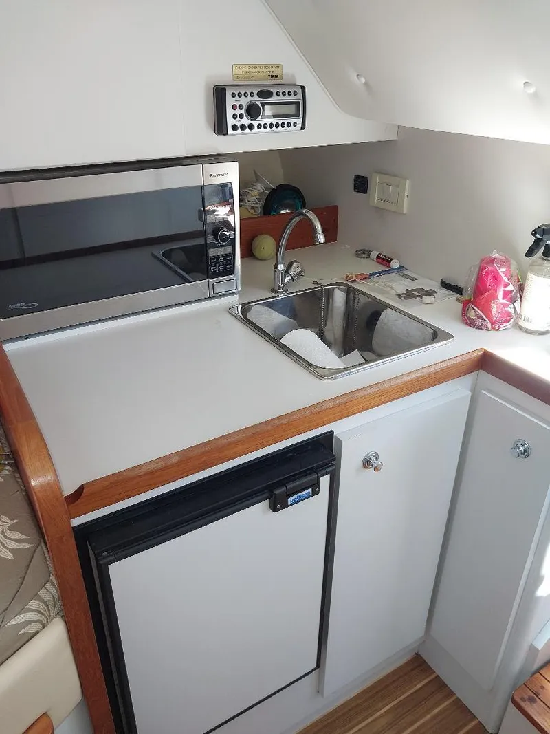 Slide: The Image of Compact kitchen area in a 2006 Tiara Yachts 2900 Coronet, featuring a sink and microwave. - 8