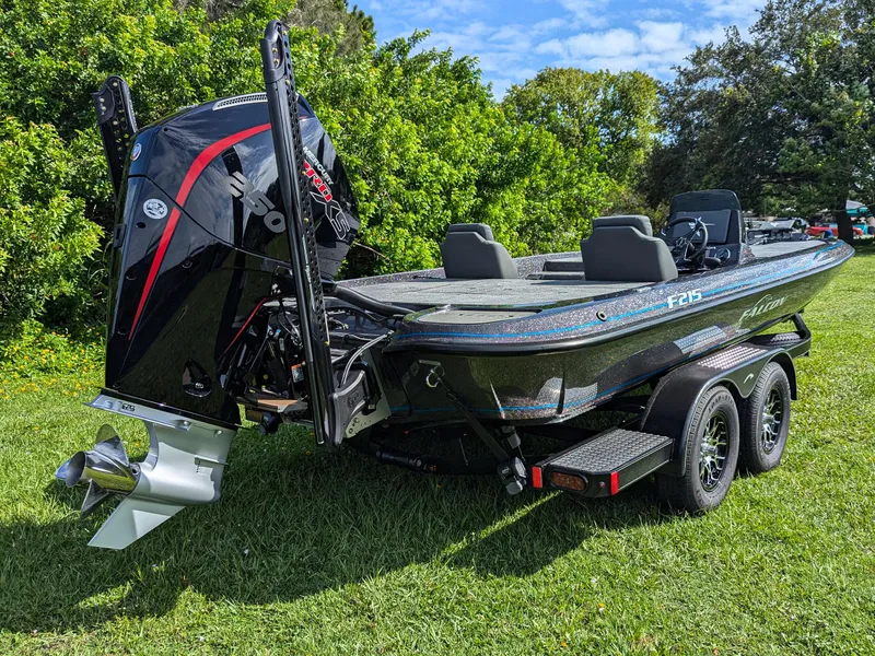 Slide: The Image of 2026 Falcon F215 boat on trailer, parked on grass, with powerful outboard motor. - 4