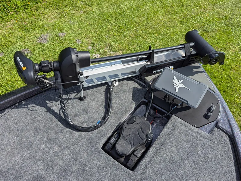 Slide: The Image of Minn Kota trolling motor on Falcon F215 boat, 2026 model, with control panel and lush grass background. - 9