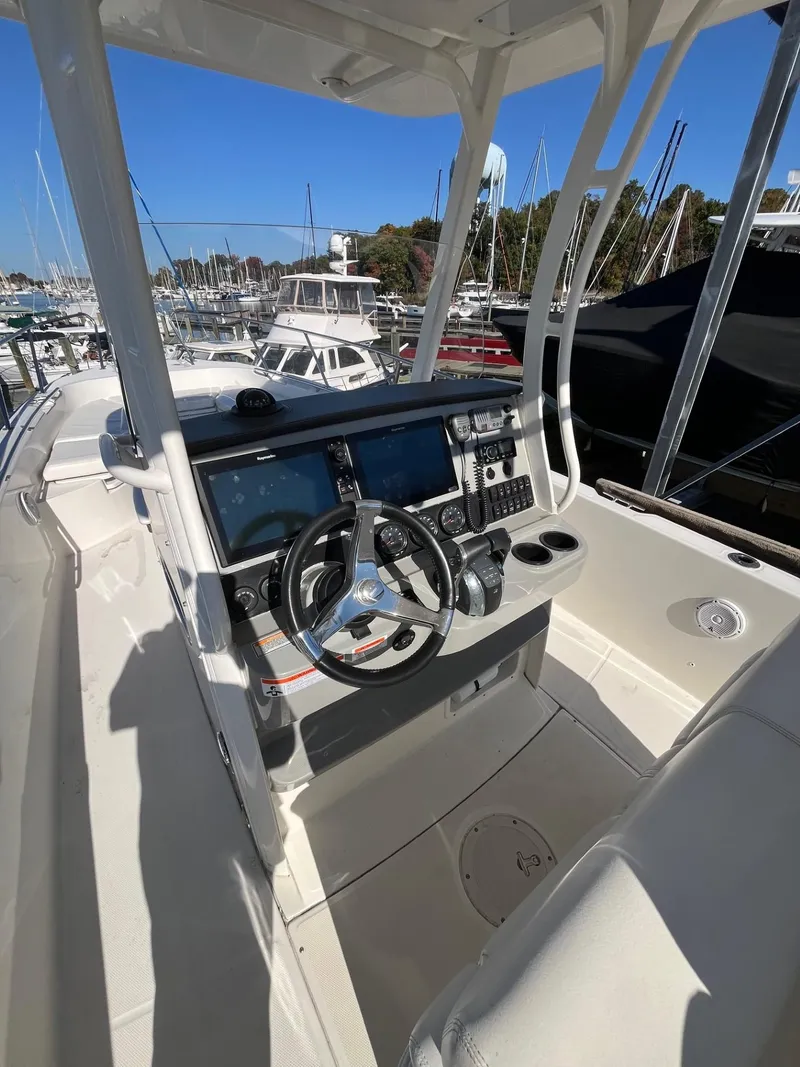 Slide: The Image of 2014 Boston Whaler 270 Dauntless boat console with steering wheel and controls. - 14