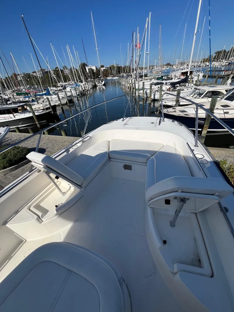 Slide: The Image of 2014 Boston Whaler 270 Dauntless boat docked in marina, surrounded by sailboats. - 7