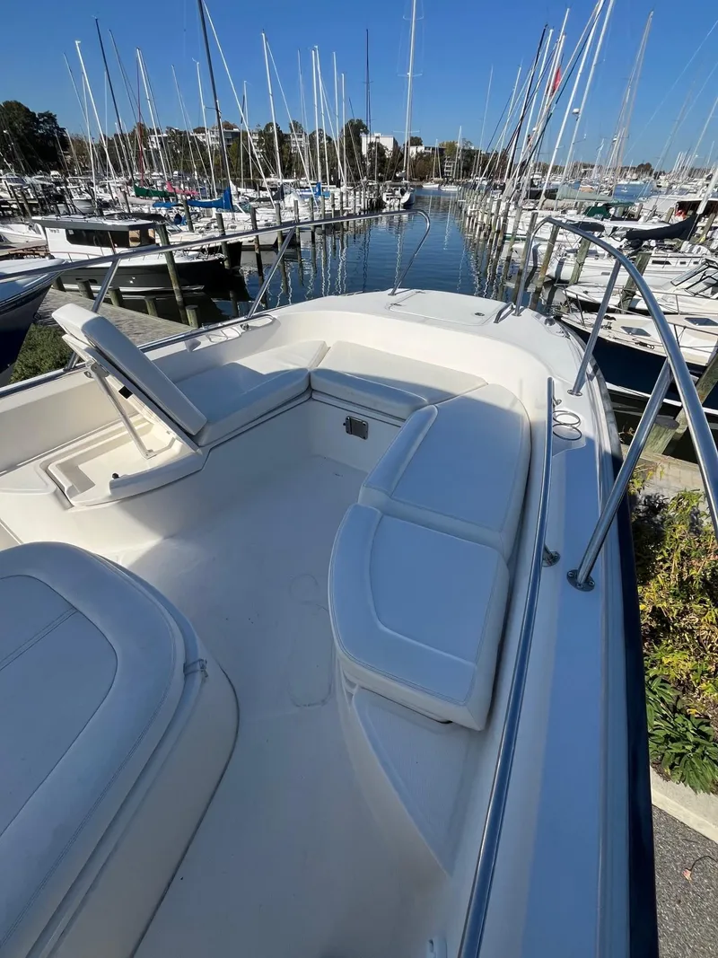 Slide: The Image of 2014 Boston Whaler 270 Dauntless boat docked in marina, featuring spacious seating area. - 8