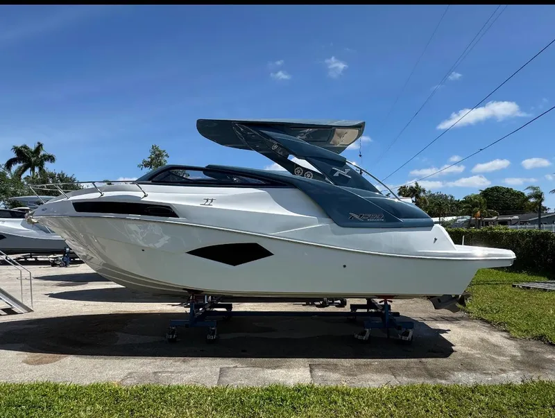 The Image of 2025 NX Boats NX290 Exclusive on display, sleek design, parked outdoors under clear blue sky. - 1