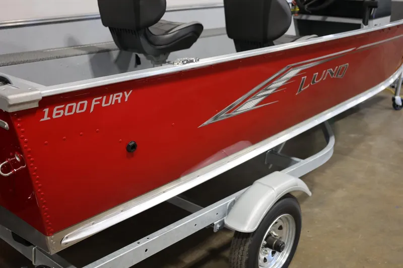 Slide: The Image of 2025 Lund 1600 Fury SS boat, red exterior, on trailer in garage setting. - 4