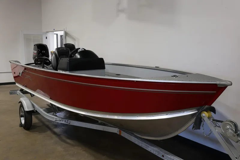 Slide: The Image of 2025 Lund 1600 Fury SS boat in red on a trailer, displayed indoors. - 5