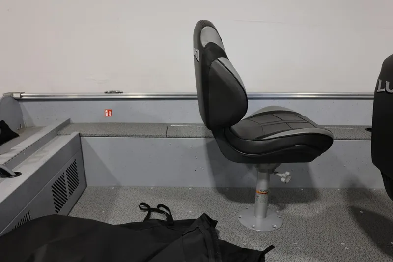 Slide: The Image of 2025 Lund 1600 Fury SS boat interior with gray seating and storage area. - 9