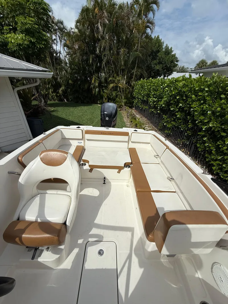 Slide: The Image of 2019 Bayliner VR4 Bowrider OB with tan and white seating, parked outdoors. - 12