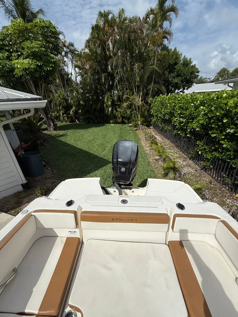 Slide: The Image of 2019 Bayliner VR4 Bowrider OB in a lush backyard setting. - 13