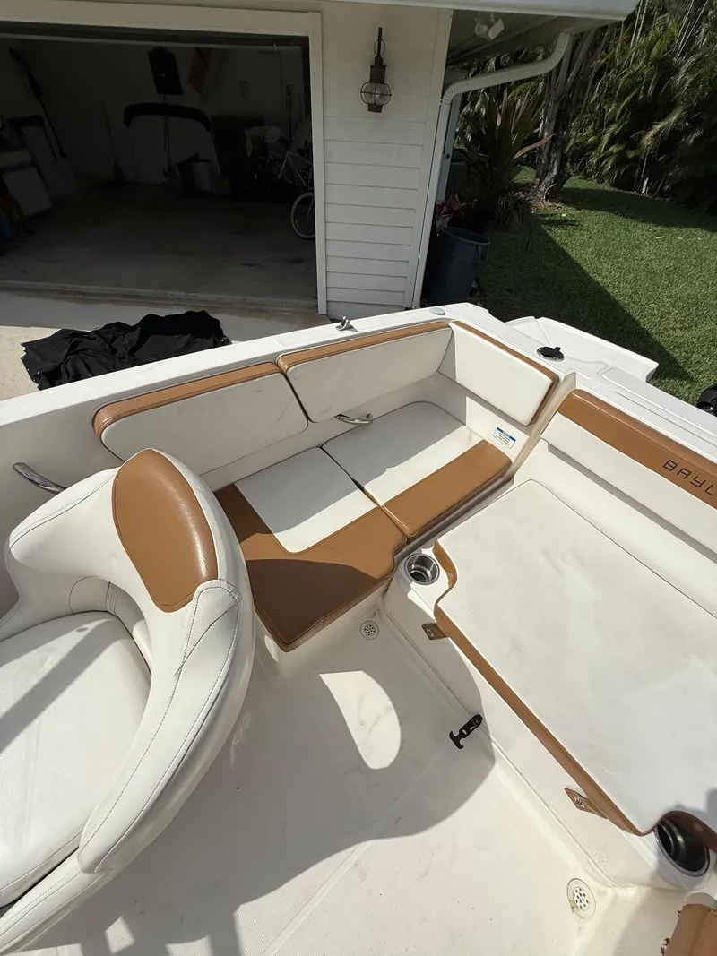 Slide: The Image of 2019 Bayliner VR4 Bowrider OB interior with white and tan seating in a garage setting. - 14