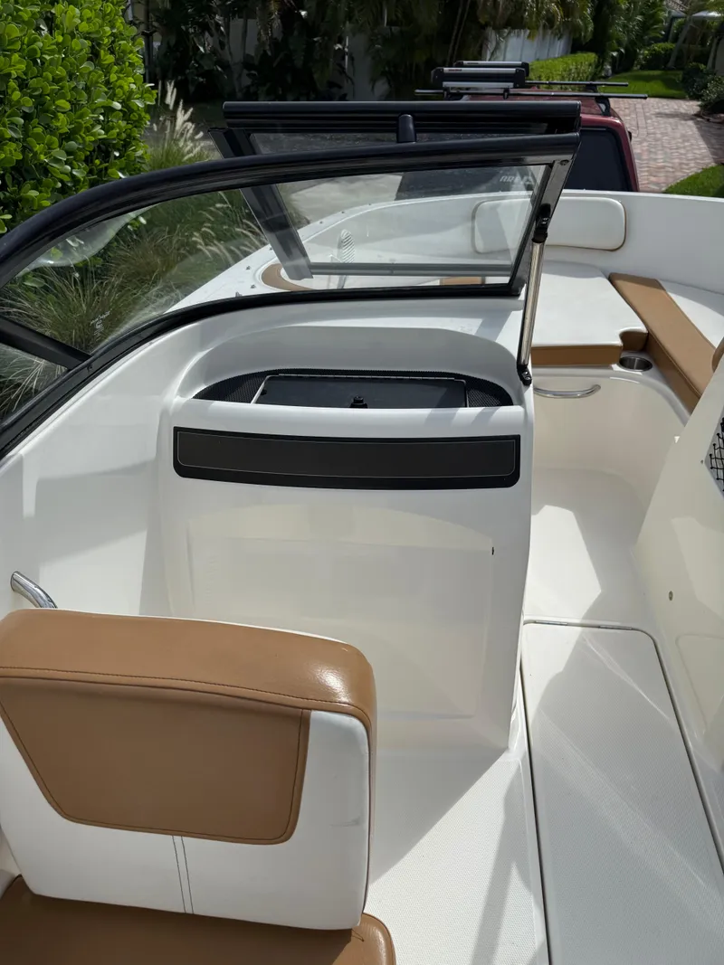 Slide: The Image of 2019 Bayliner VR4 Bowrider OB interior with tan and white seating, open windshield, and sleek design. - 9