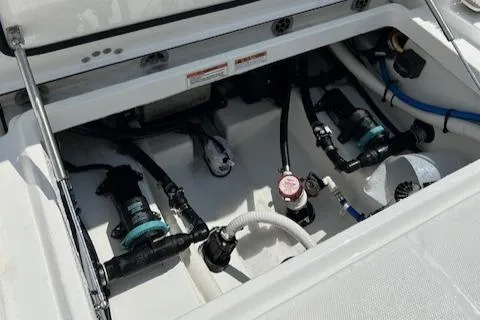Slide: The Image of 2019 Blackfin 242 CC boat engine compartment with visible pumps and hoses. - 10