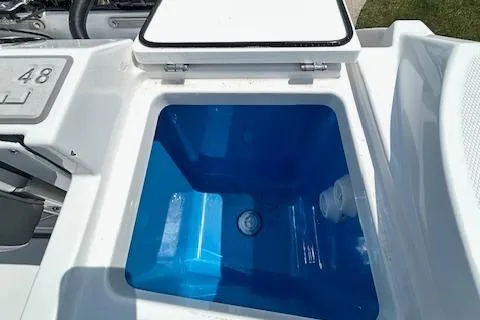 Slide: The Image of Livewell compartment on a 2019 Blackfin 242 CC boat, featuring a blue interior. - 13