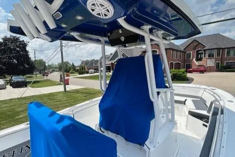 Slide: The Image of 2019 Blackfin 242 CC boat with blue covers, parked in a residential area. - 15