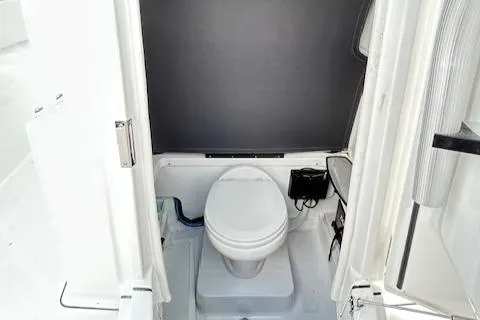 Slide: The Image of 2019 Blackfin 242 CC boat interior with a compact marine toilet. - 22