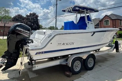 Slide: The Image of 2019 Blackfin 242 CC boat on trailer with Mercury engine, parked in residential area. - 3