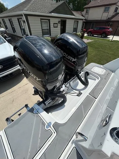 Slide: The Image of 2019 Blackfin 242 CC boat with dual Mercury outboard engines in a residential driveway. - 4