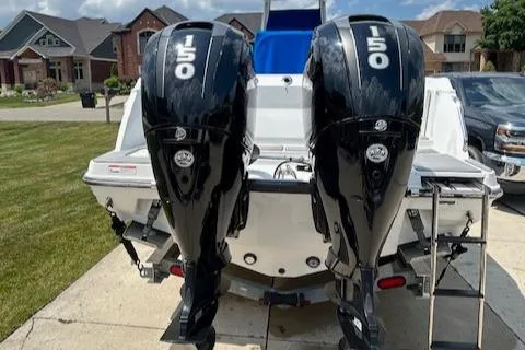 Slide: The Image of 2019 Blackfin 242 CC boat with dual 150 horsepower engines, parked in a residential driveway. - 6