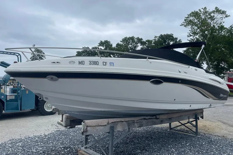 The Image of 2003 Chaparral 235 SSi boat on display, white hull, parked on a stand. - 0