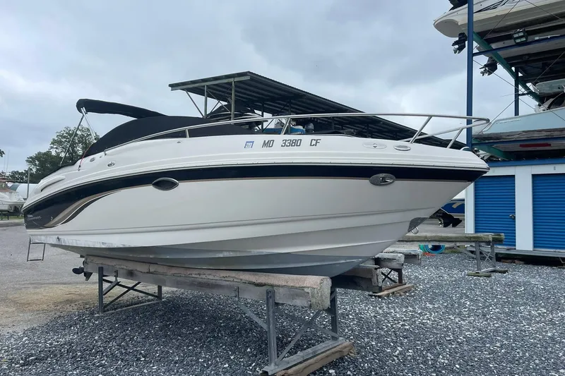 Slide: The Image of 2003 Chaparral 235 SSi boat on a trailer, parked outdoors under cloudy skies. - 1