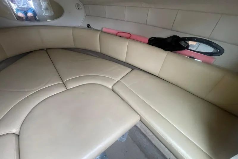 Slide: The Image of 2003 Chaparral 235 SSi boat interior with beige seating and small window. - 11