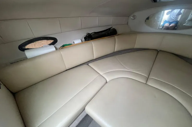 Slide: The Image of Interior of a 2003 Chaparral 235 SSi boat with beige seating and small window. - 12