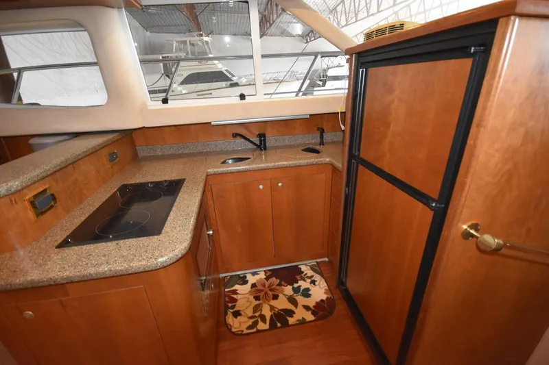 Slide: The Image of 2000 Cruisers Yachts 4450 Express Motoryacht kitchen with stove, sink, and refrigerator. - 39