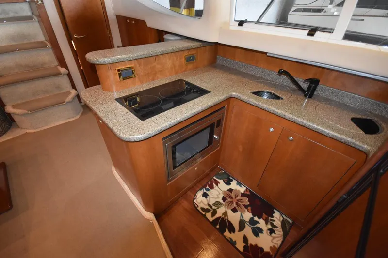 Slide: The Image of 2000 Cruisers Yachts 4450 Express Motoryacht kitchen with stove, sink, and microwave. - 42