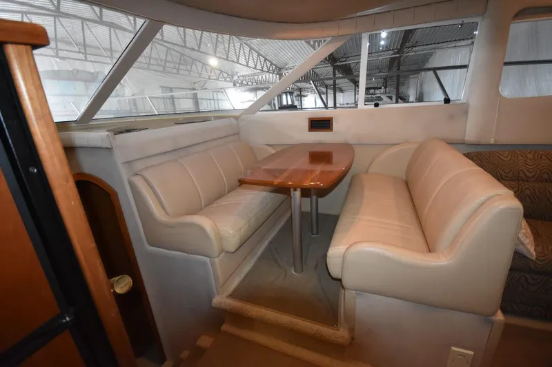 Slide: The Image of Interior of 2000 Cruisers Yachts 4450 Express Motoryacht with beige seating and wooden table. - 43