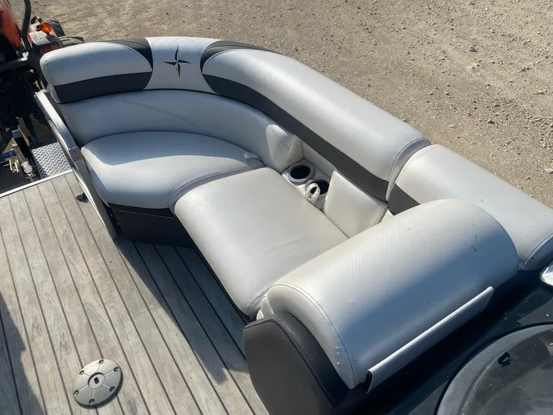 Slide: The Image of 2015 Berkshire 233SL STS boat seating with gray upholstery and cup holders on deck. - 10