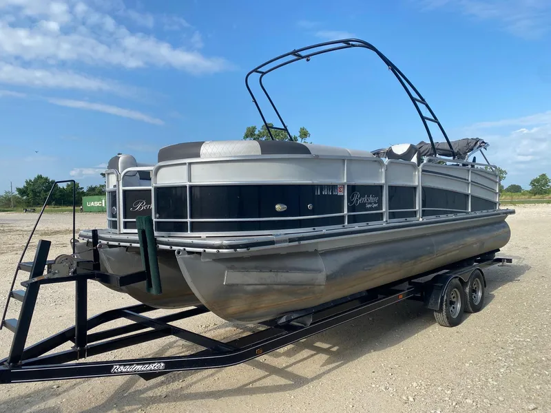Slide: The Image of 2015 Berkshire 233SL STS pontoon boat on trailer under blue sky. - 2