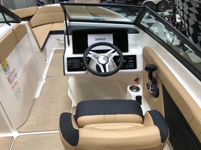 Slide: The Image of 2025 Sea Ray SPX 230 boat interior with beige seating and modern steering console. - 6