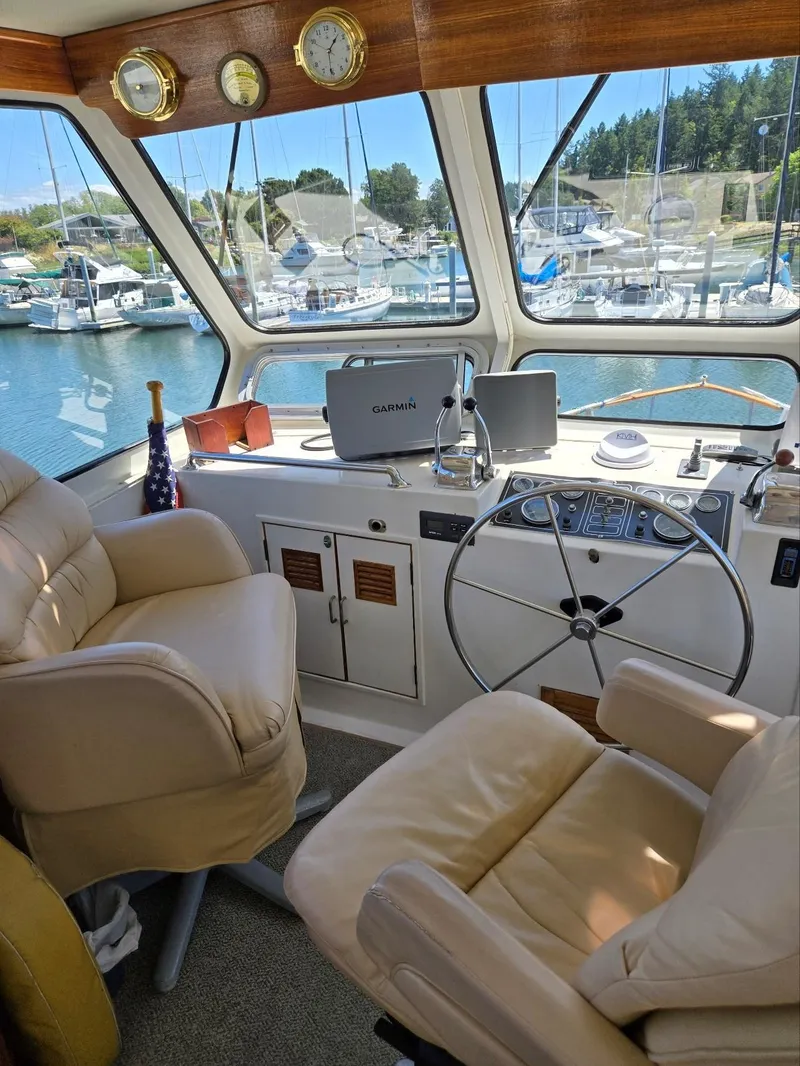 Slide: The Image of 1983 Ocean Alexander 43 Flush Aft Deck yacht helm with leather seats and navigation equipment. - 18