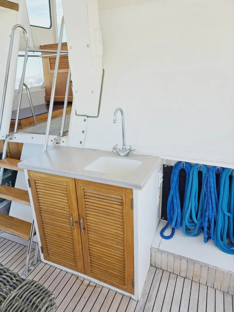 Slide: The Image of 1983 Ocean Alexander 43 Flush Aft Deck with sink, wooden cabinet - 29