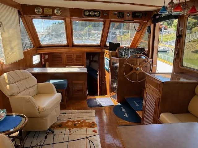 Slide: The Image of 1983 Ocean Alexander 43 Flush Aft Deck yacht interior with wood paneling and steering wheel. - 38