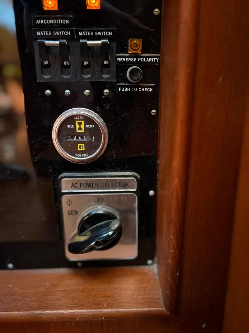Slide: The Image of Control panel of a 1986 Grand Banks 36 Classic boat with switches and power selector. - 12